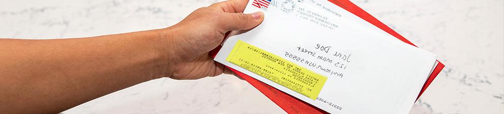 Person holding stack of forwarded 美国邮政总局 mail.